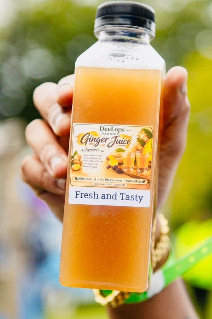 Hand holding a bottle of DeeLops Organic Ginger Juice